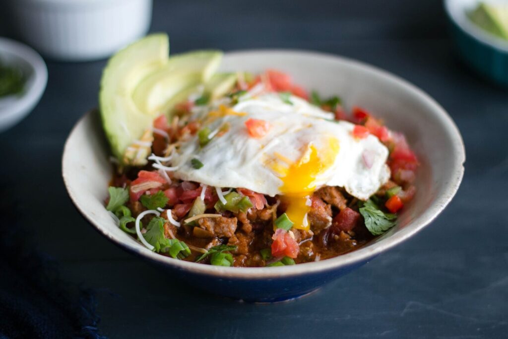 Breakfast chili with a fried egg and avocado