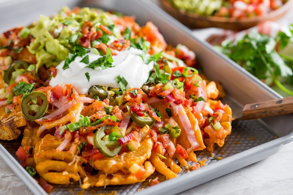 Loaded Nachos with seasoned waffle fries, bacon, Canadian Bacon, sour cream, and cheese.