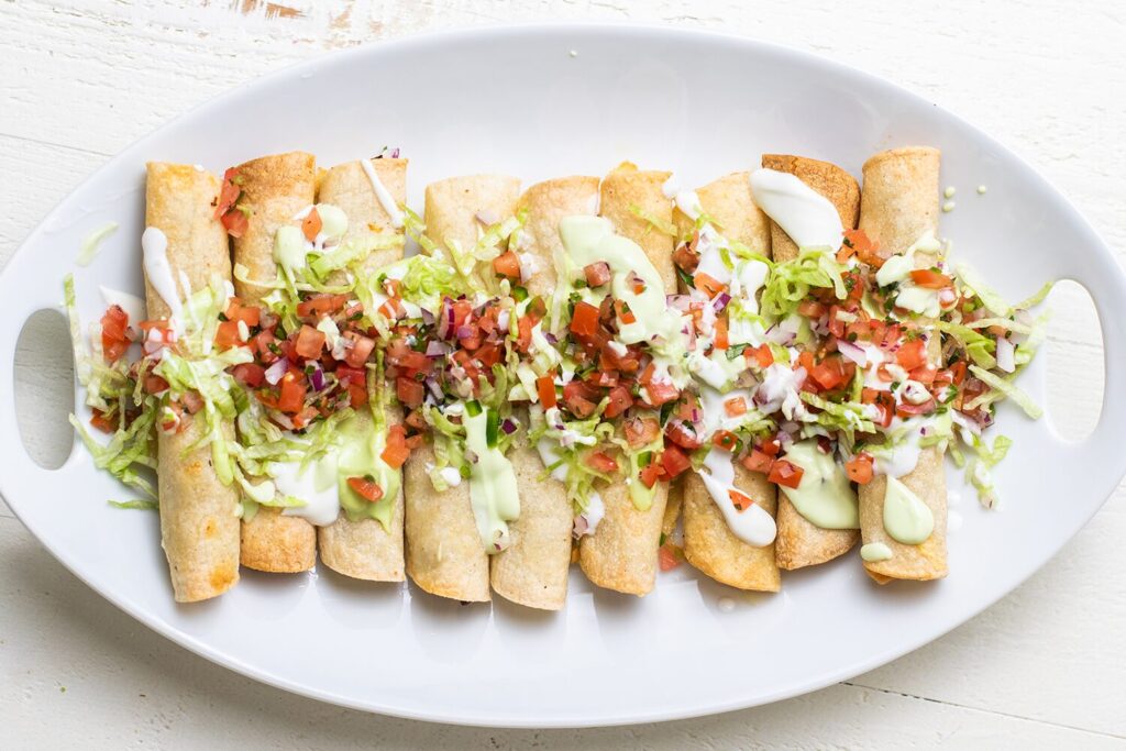 Breakfast taquitos with chicken sausage, scrambled eggs, and cheese, topped with pico de gallo