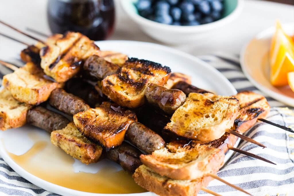 Breakfast kebabs with French toast and sausage, served with maple syrup.